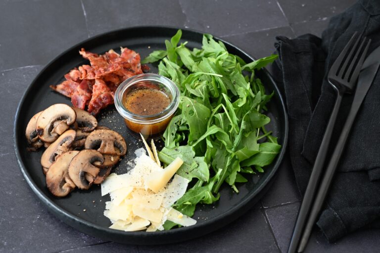 Rucola Salat mit knusprigem Bacon und gebratenen Champignons